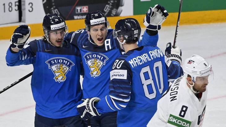 Хоккеисты команды Финляндии празднуют победную шайбу